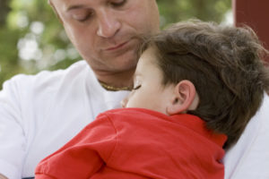 boy sleeping on dad